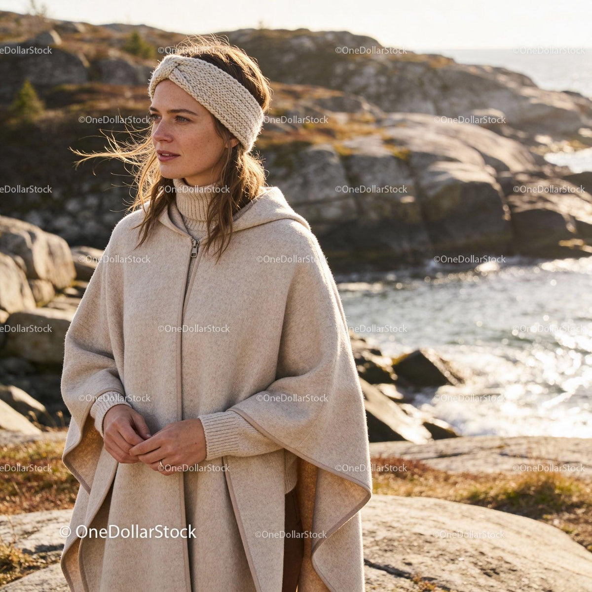 Woman in cozy knitwear enjoying seaside autumn breeze