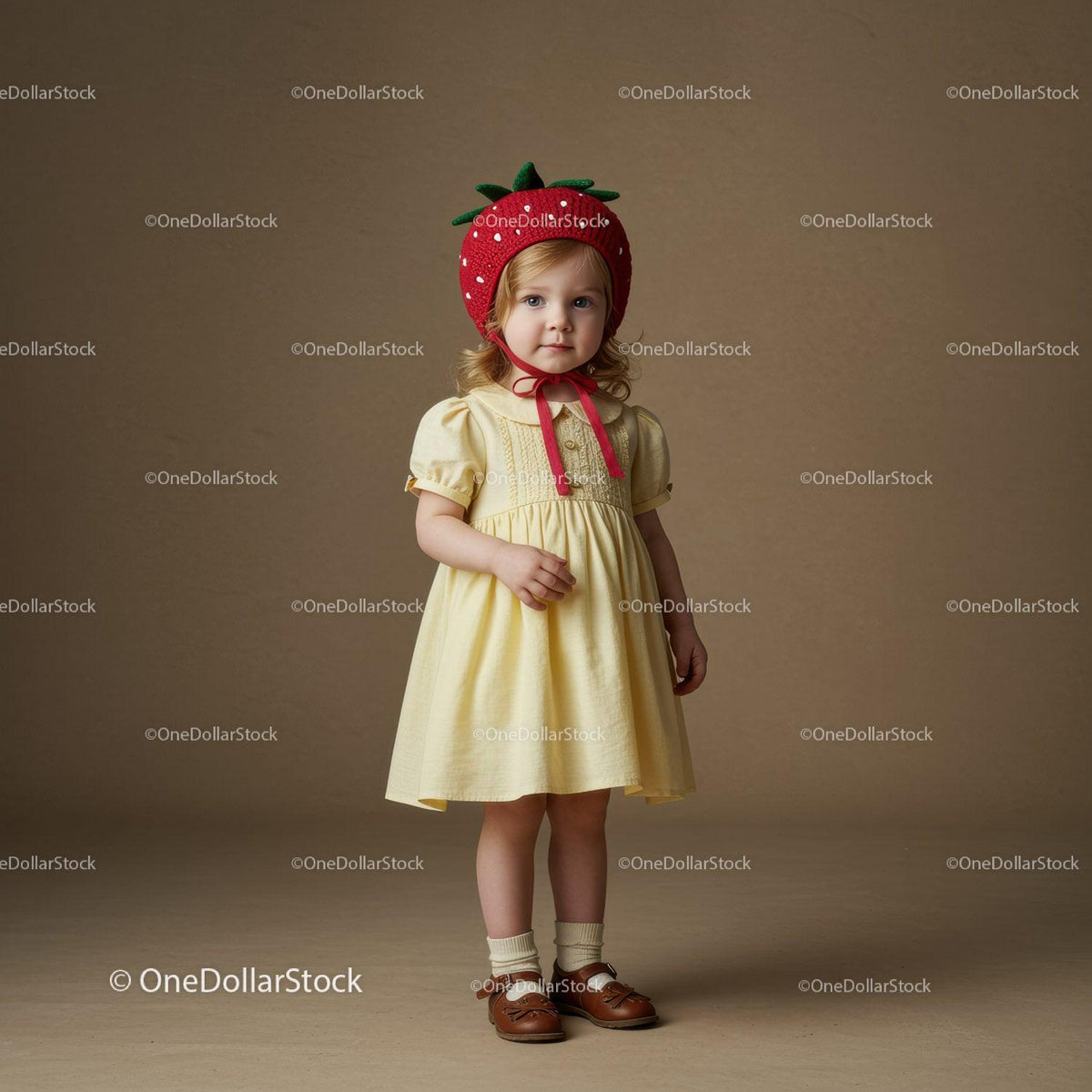 Toddler girl wearing strawberry hat and yellow dress