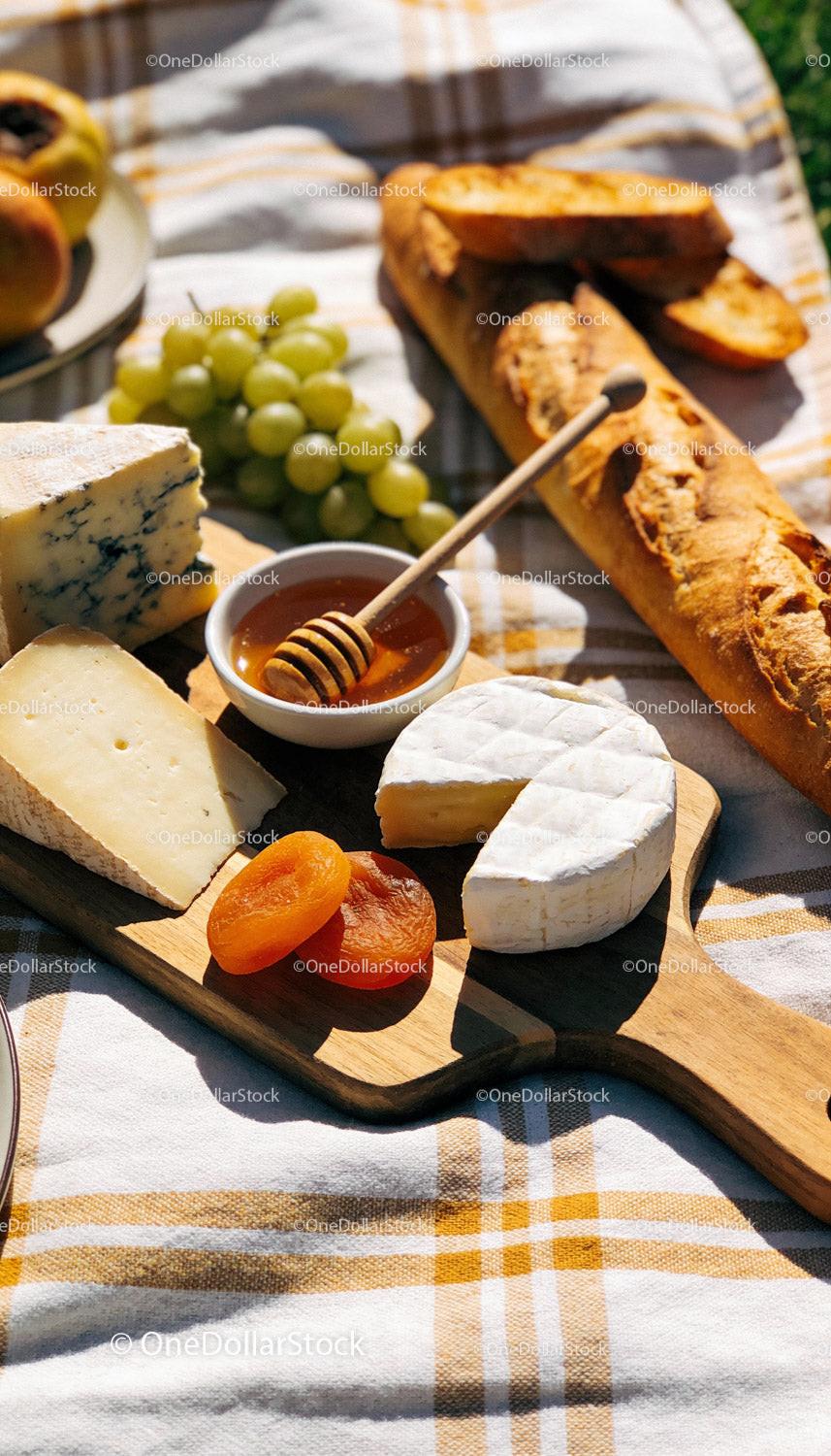 Cheese platter with fresh fruit and honey for picnic