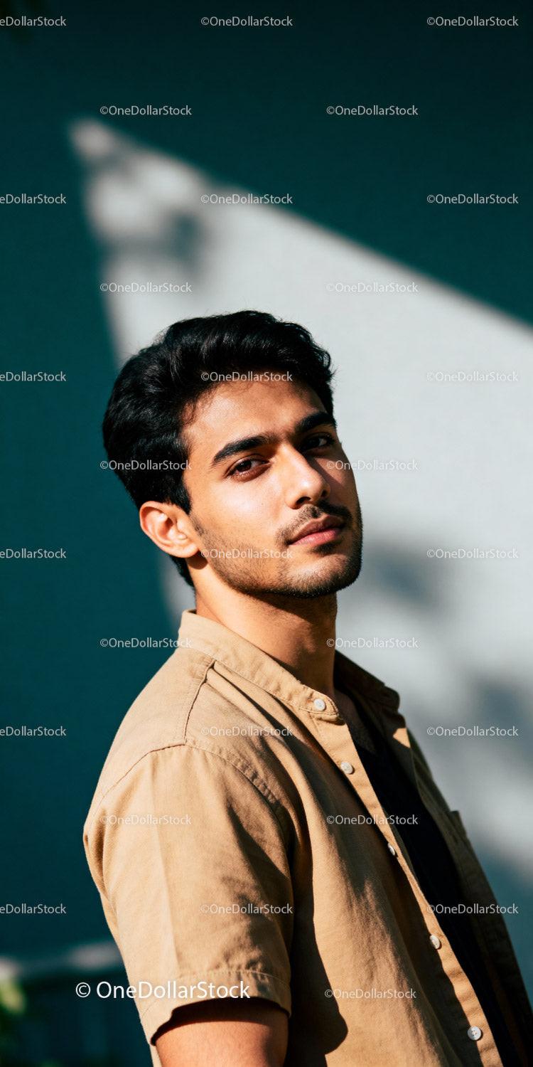 Young man standing in sunlight with contemplative expression