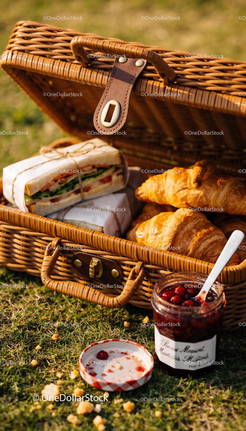 Fresh picnic basket with sandwiches croissants and jam