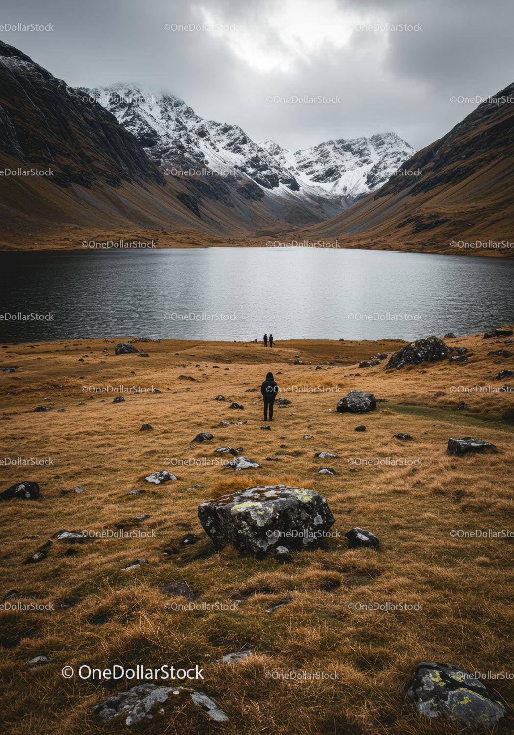Scenic Mountain Lake with Snow-Capped Peaks and Rocky Terrain