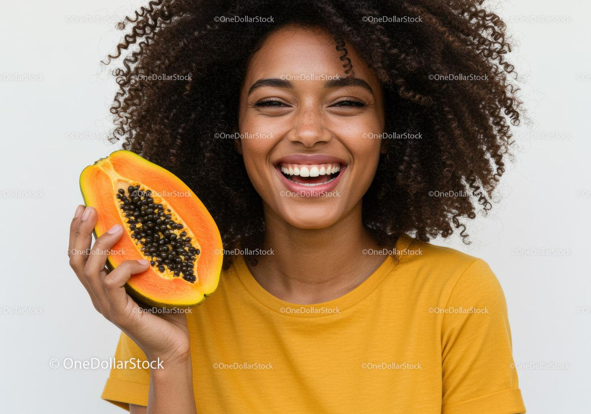 Smiling Woman Holding a Fresh Papaya with Black Seeds in Bright Yellow Shirt