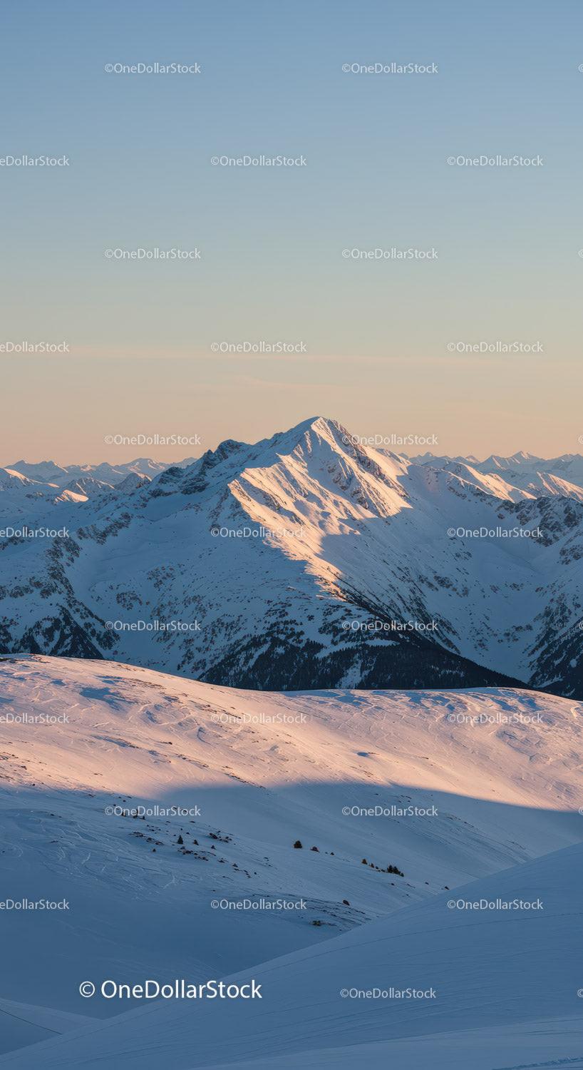 Snowy mountain peak glowing in soft evening light