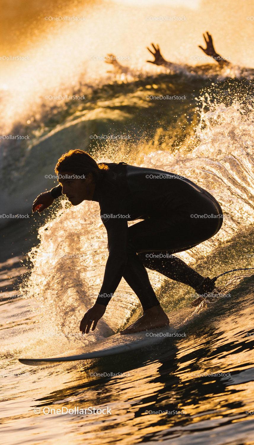 Surfer carving a wave at golden hour in wetsuit