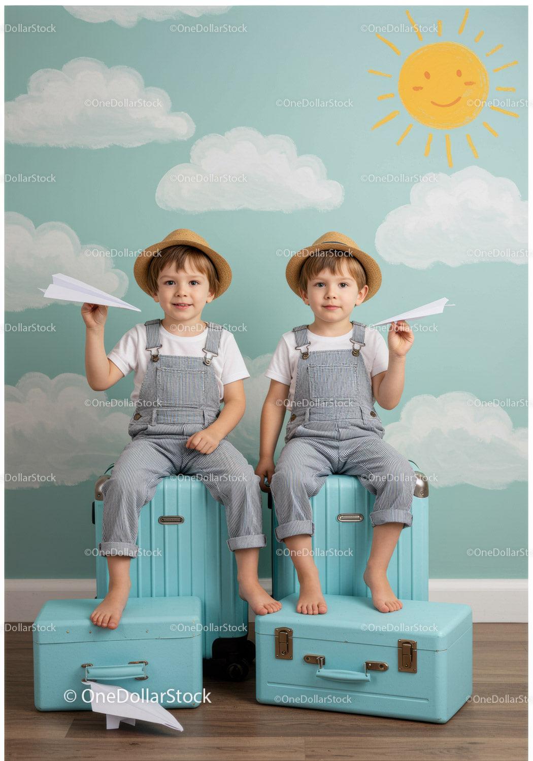 Twin boys playing with paper planes on blue suitcases