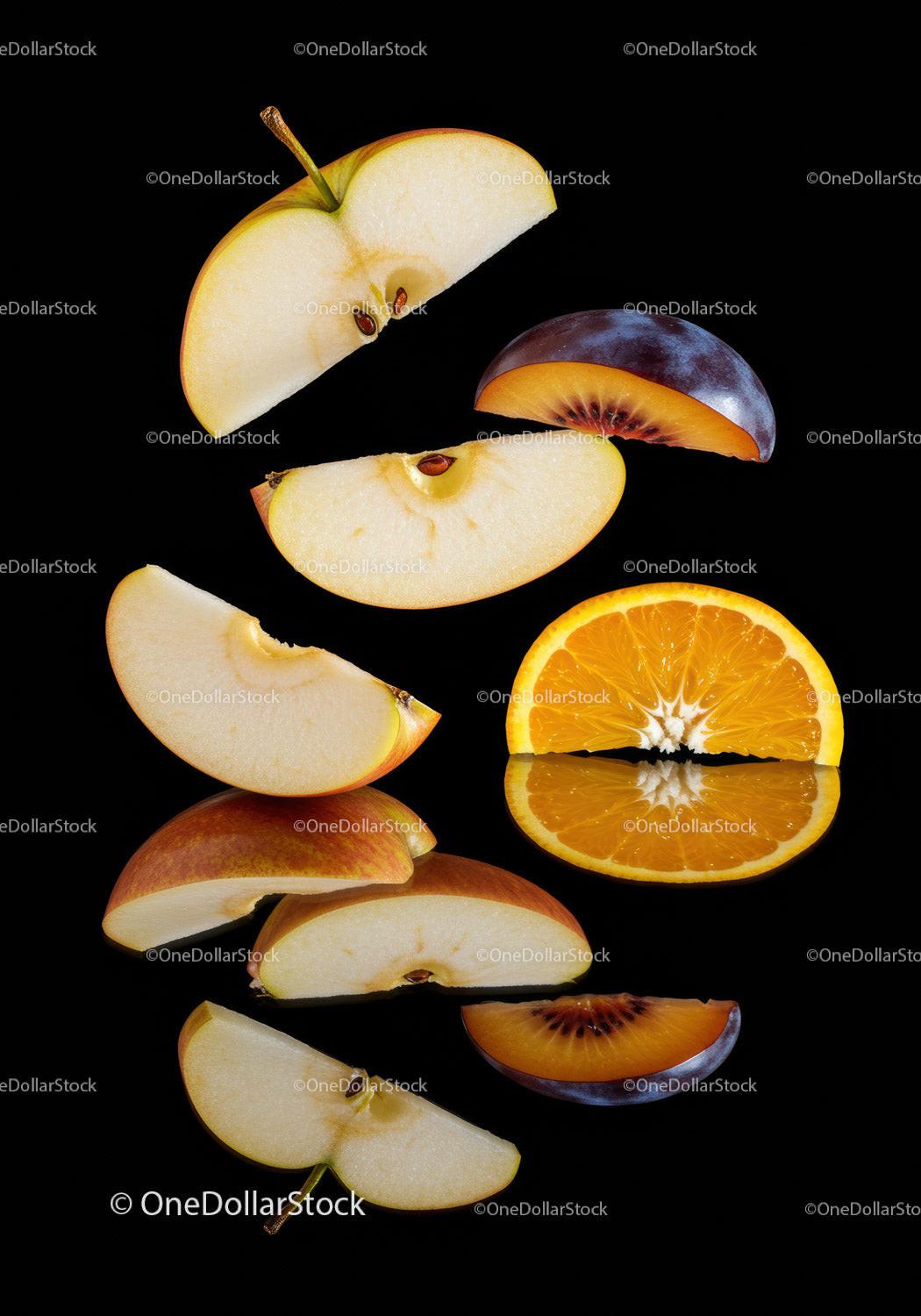 Sliced apples plum and orange on black background