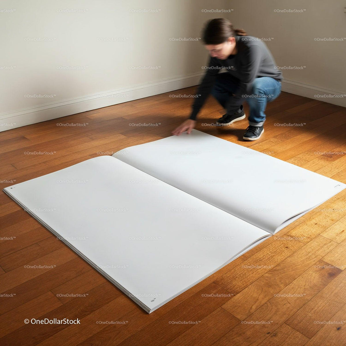 Person kneeling to flip pages of oversized blank book JPG Mockup Image preview