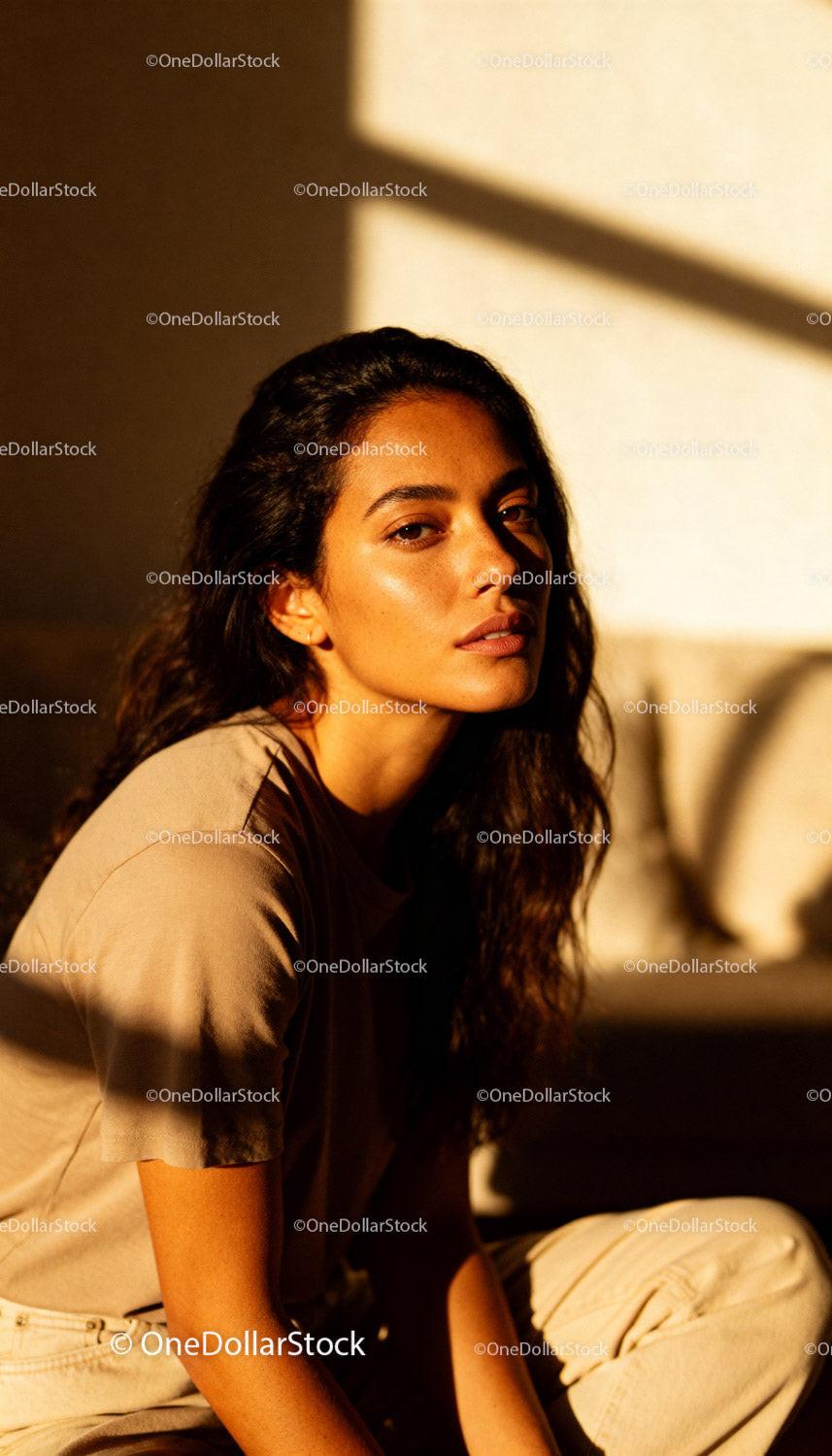 Woman bathed in warm sunlight with thoughtful expression