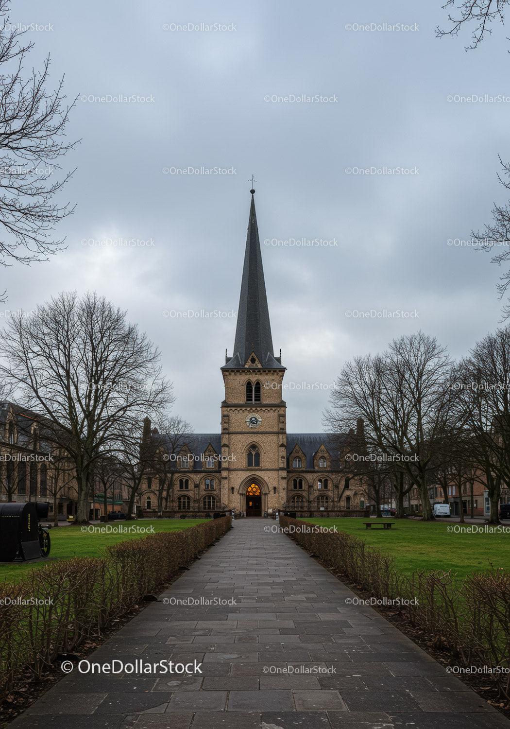 Historic church tower under overcast sky in quiet park