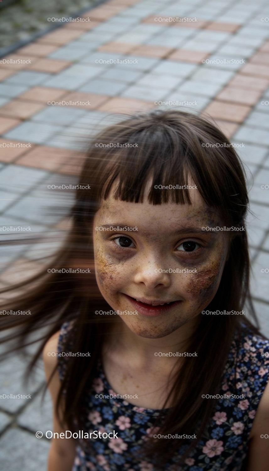 Smiling Girl with Freckles and Windblown Hair Outdoors