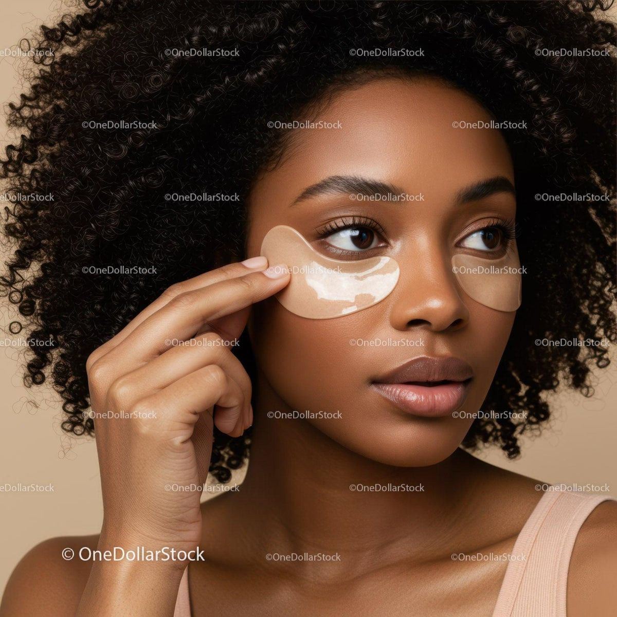 Close-up of a woman with under eye patches applying skincare routine