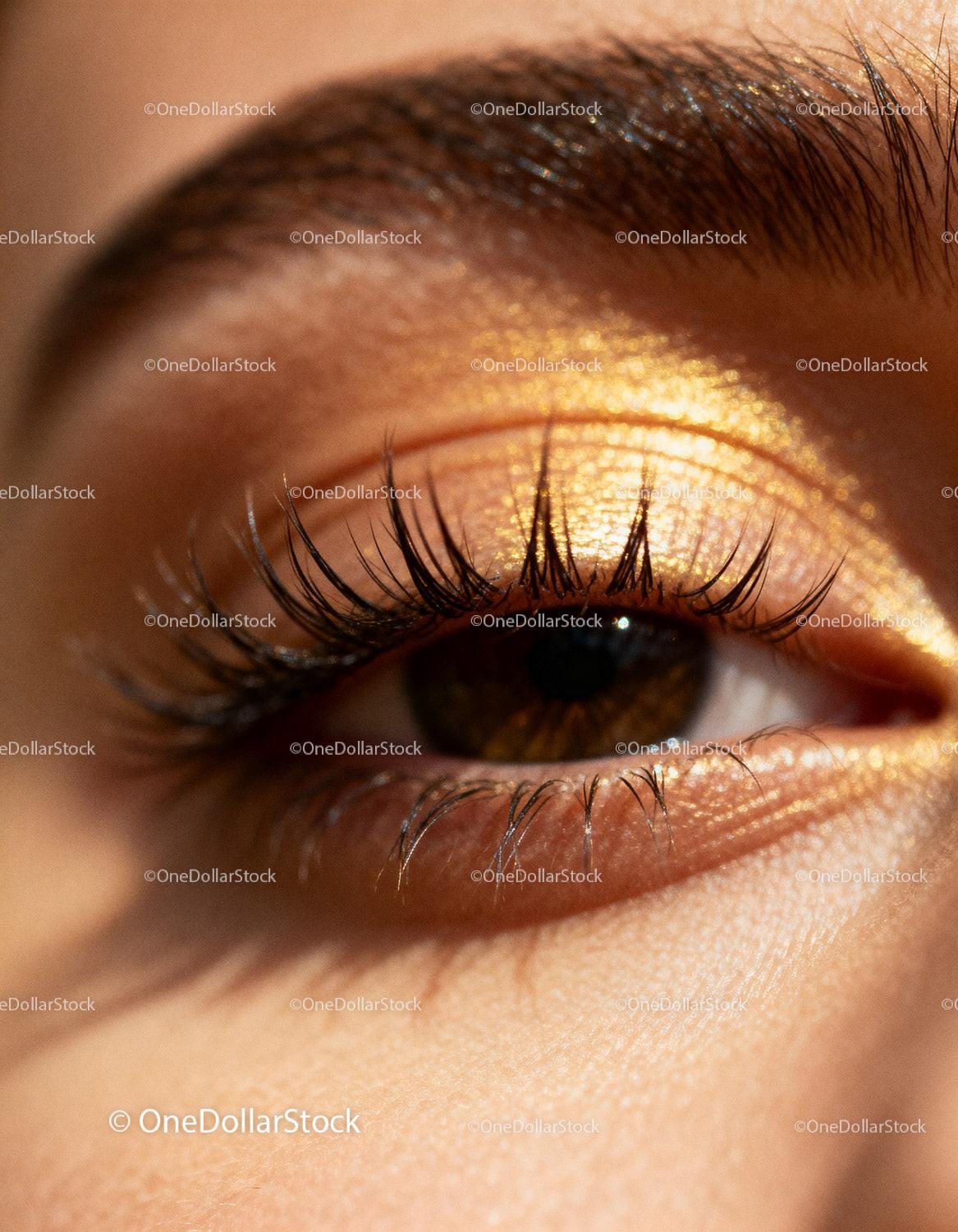 Closeup of brown eye with glowing golden eyeshadow