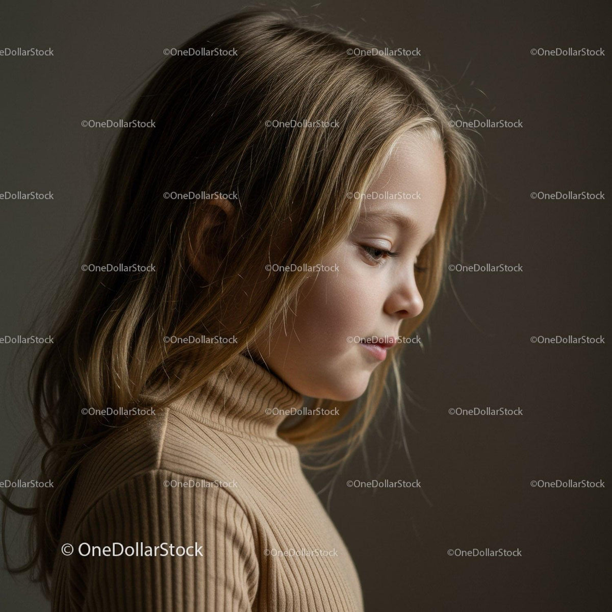 Young girl in beige turtleneck looking thoughtfully down