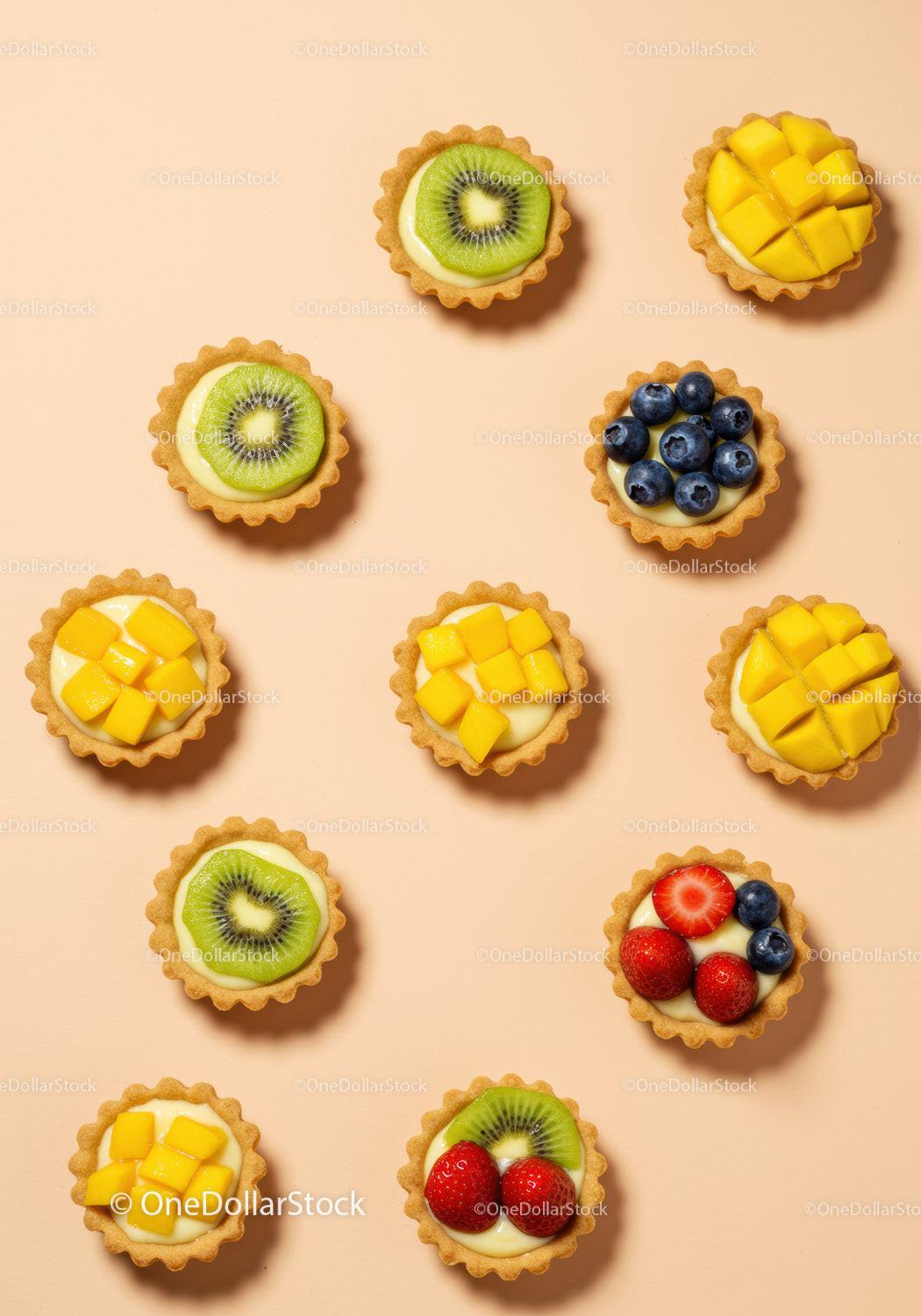Assorted fresh fruit tarts on pastel background