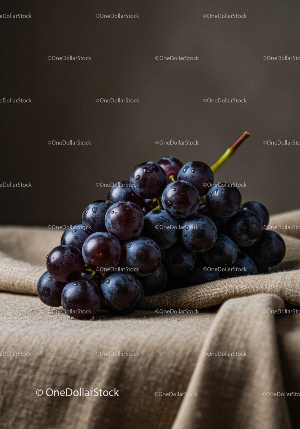 Fresh black grapes resting on textured fabric surface
