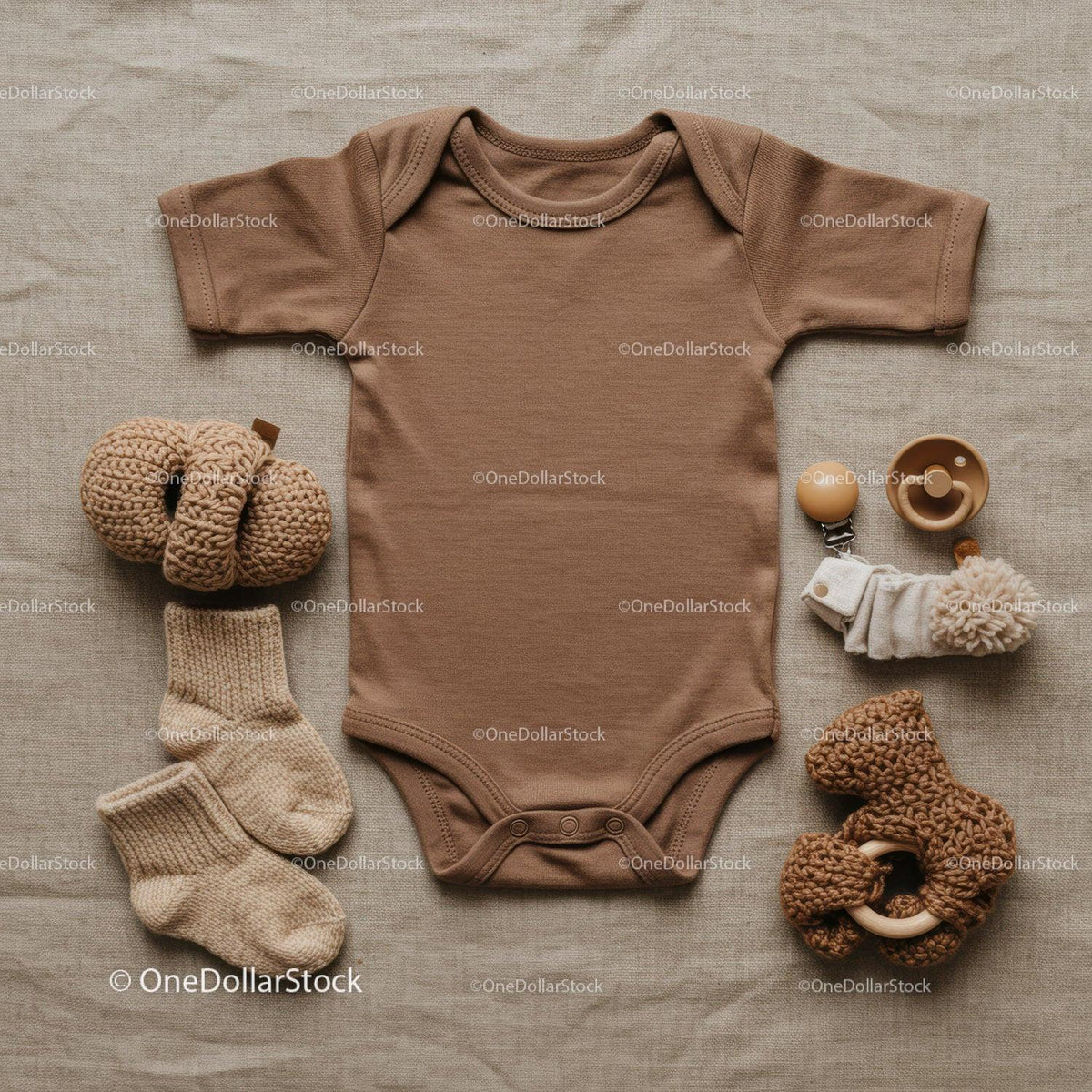 Neutral toned baby clothing and soft toys flat lay
