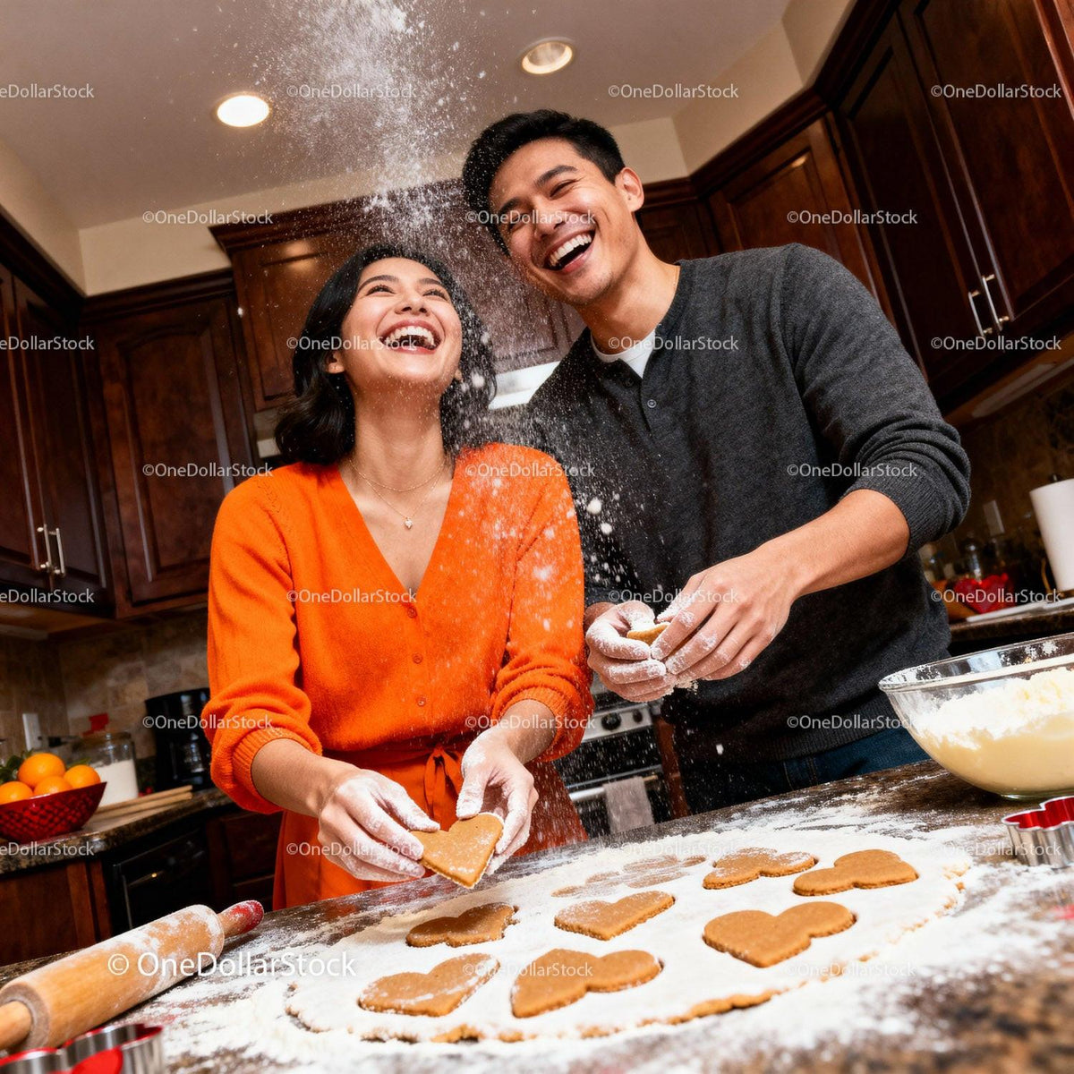 Couple Laughing While Baking Heart Shaped Cookies