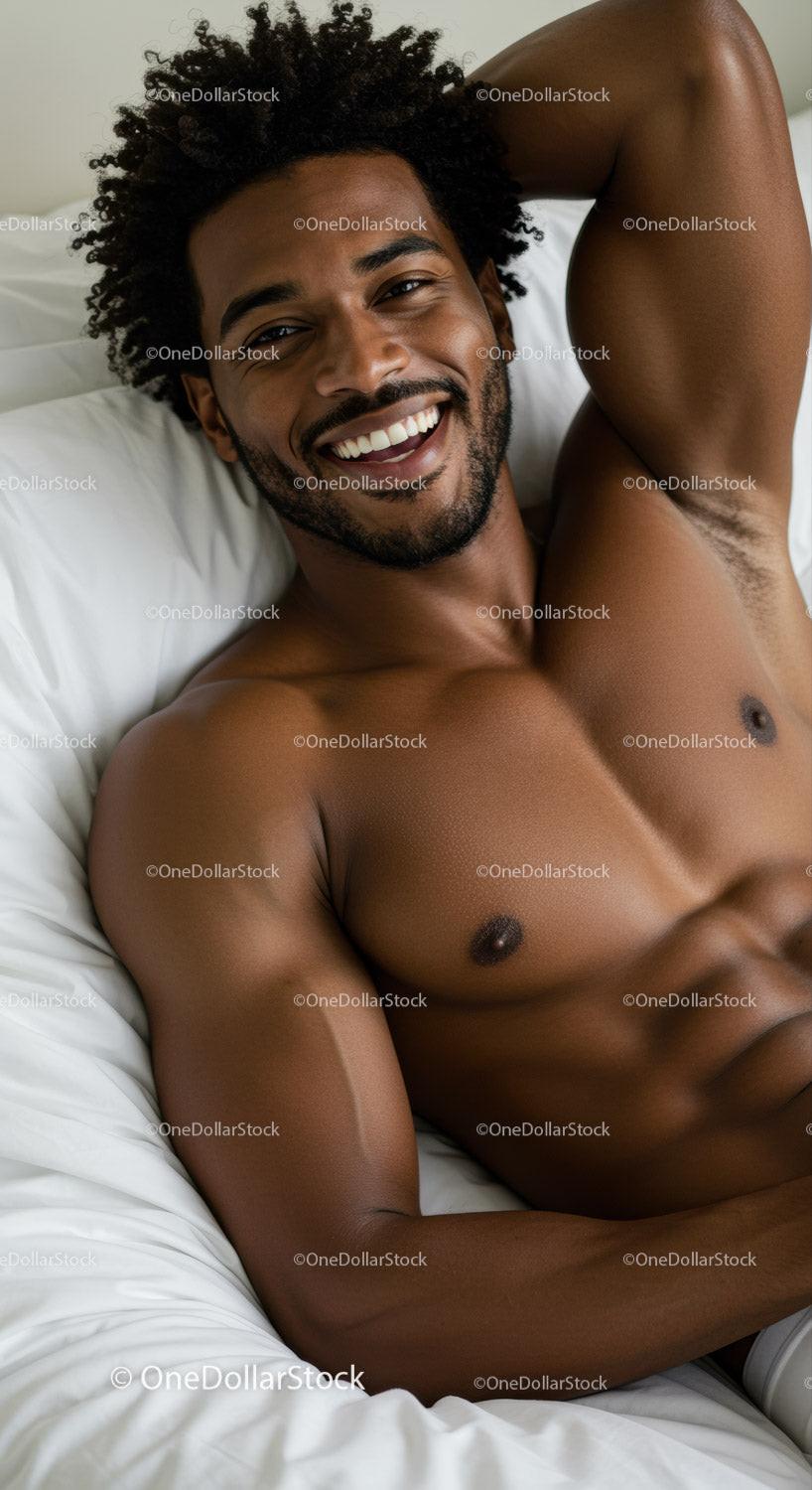 Smiling shirtless man relaxing comfortably in bed