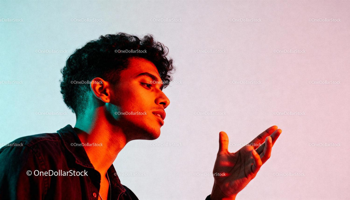 Young man expressing emotion with vibrant colored light