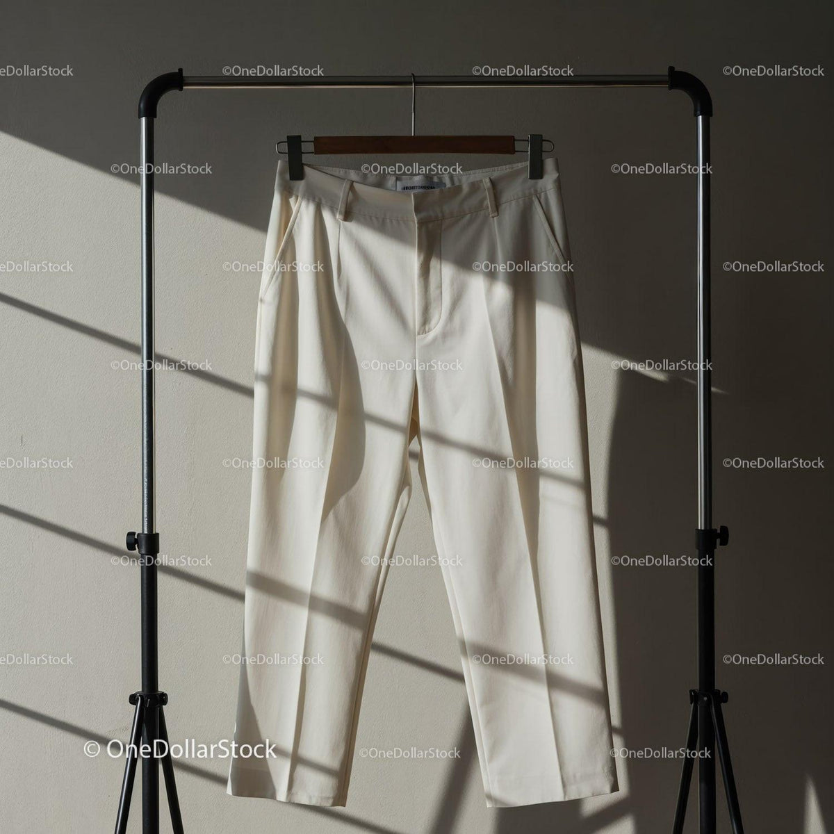 Cream Colored Dress Pants Hanging on Metal Rack JPG Mockup Image preview