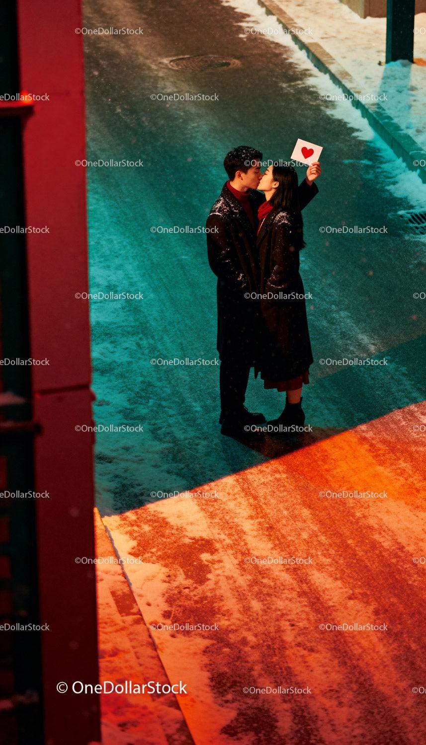 Couple sharing a romantic kiss on a snowy street
