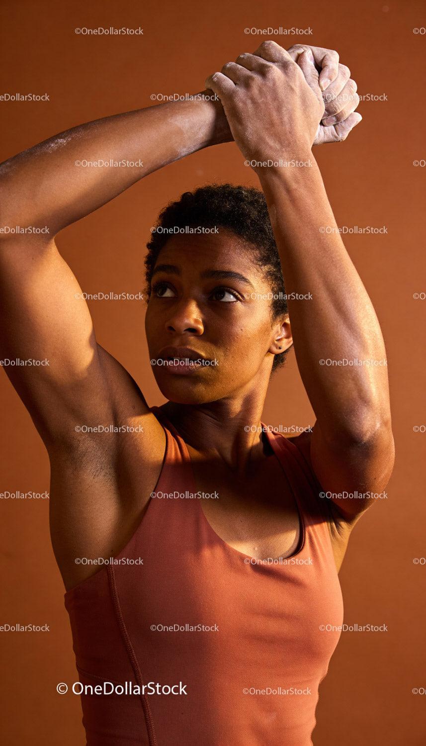 Focused Athlete Stretching Arms Against Warm Background