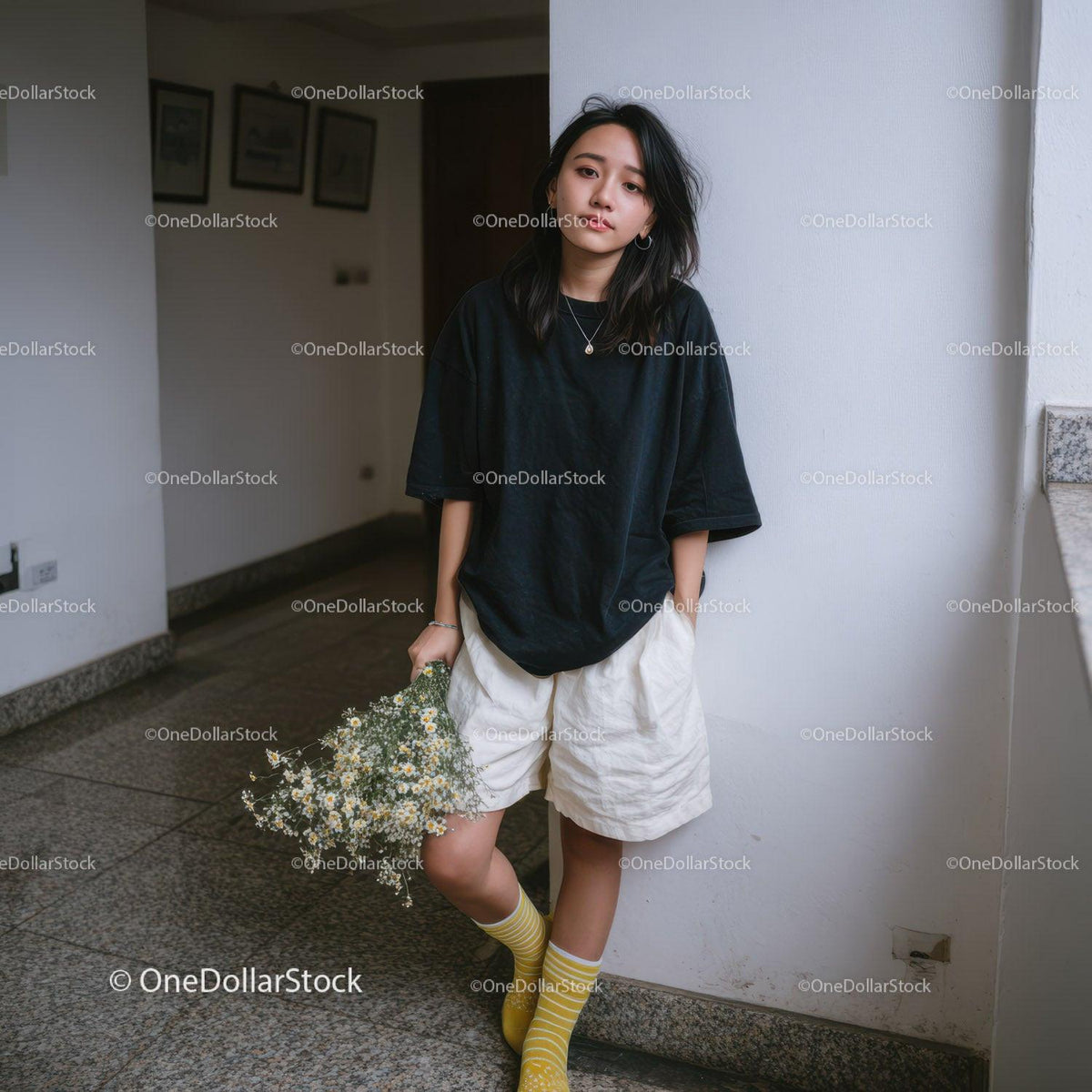 Casual Young Woman Wearing Black T-Shirt and Yellow Socks Holding Daisies