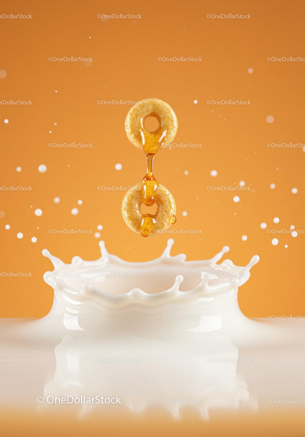 Honey Dripping Over Two Cheerios Into Splashing Milk