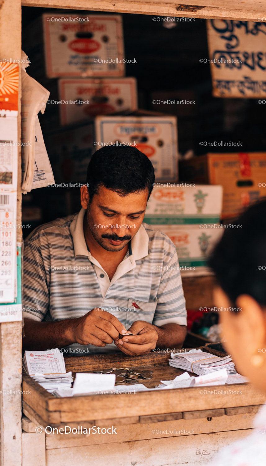 Man Counting Coins in Small Traditional Shop