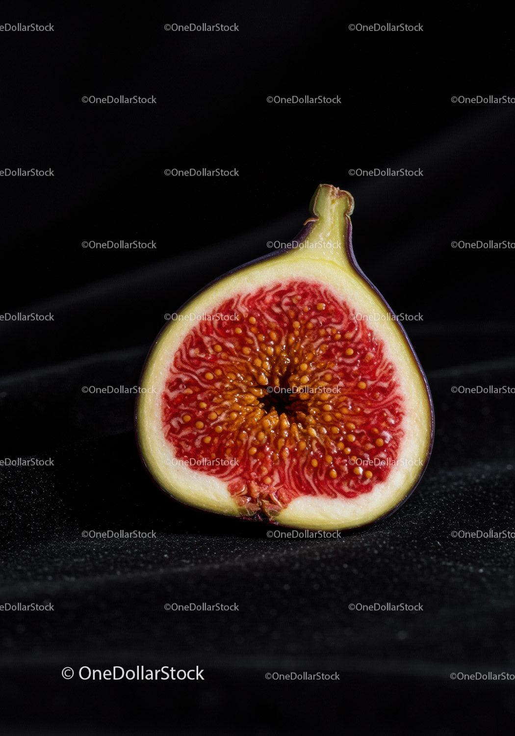 Close up of ripe fig cut in half on black background
