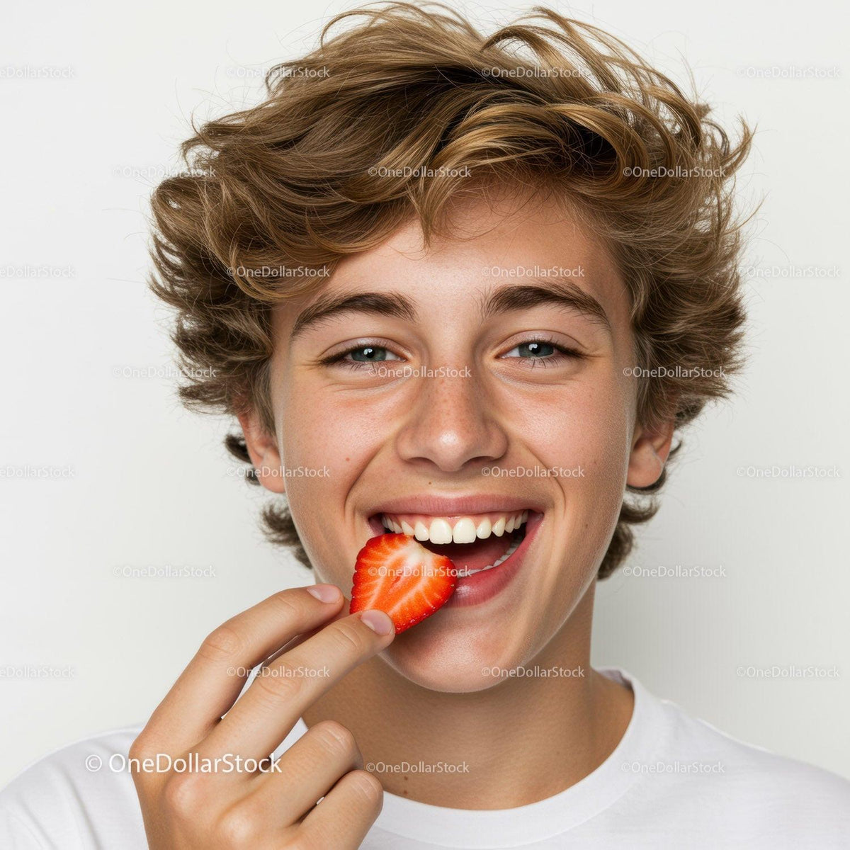 Joyful Teenage Boy Enjoying Fresh Strawberry with Bright Smile