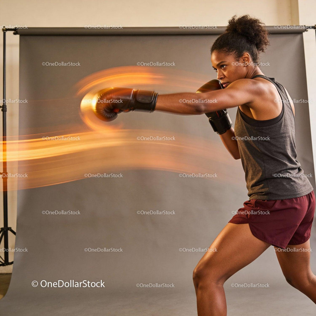 Focused female boxer training with powerful motion effect