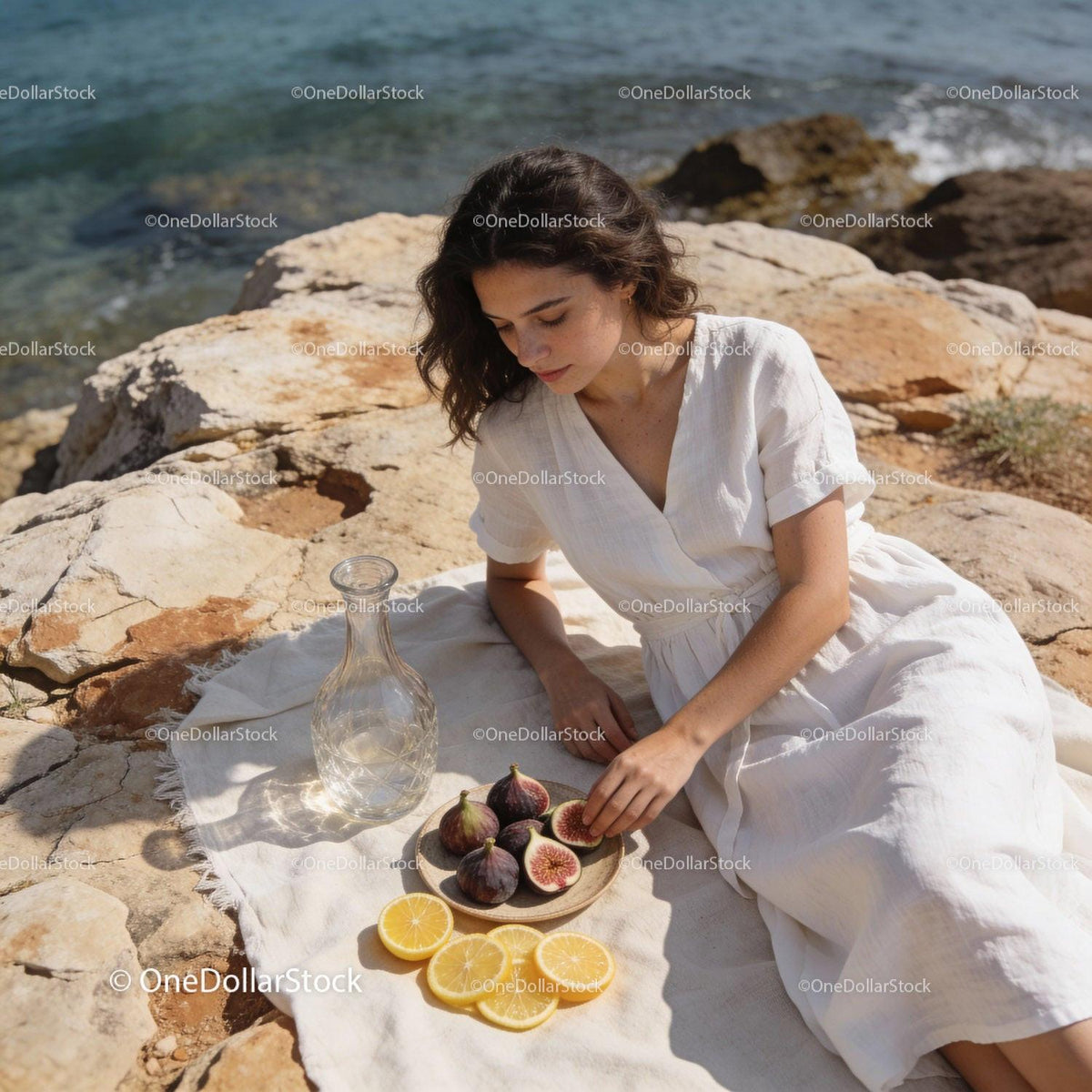Woman enjoying figs and lemon slices by the sea