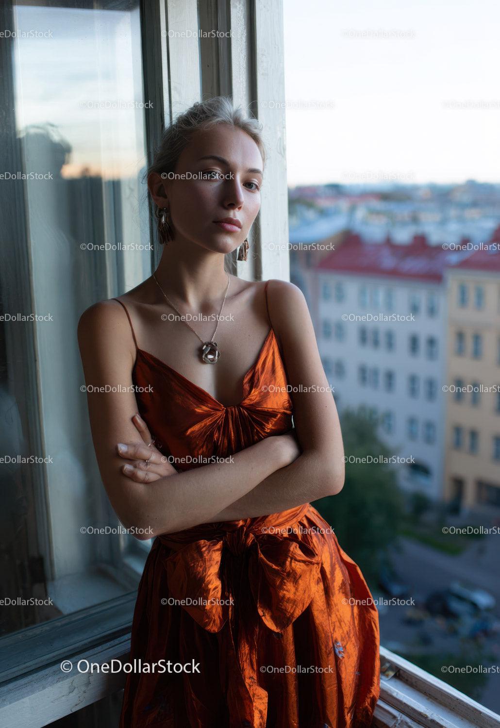 Elegant Woman in Orange Satin Dress by Window with City View