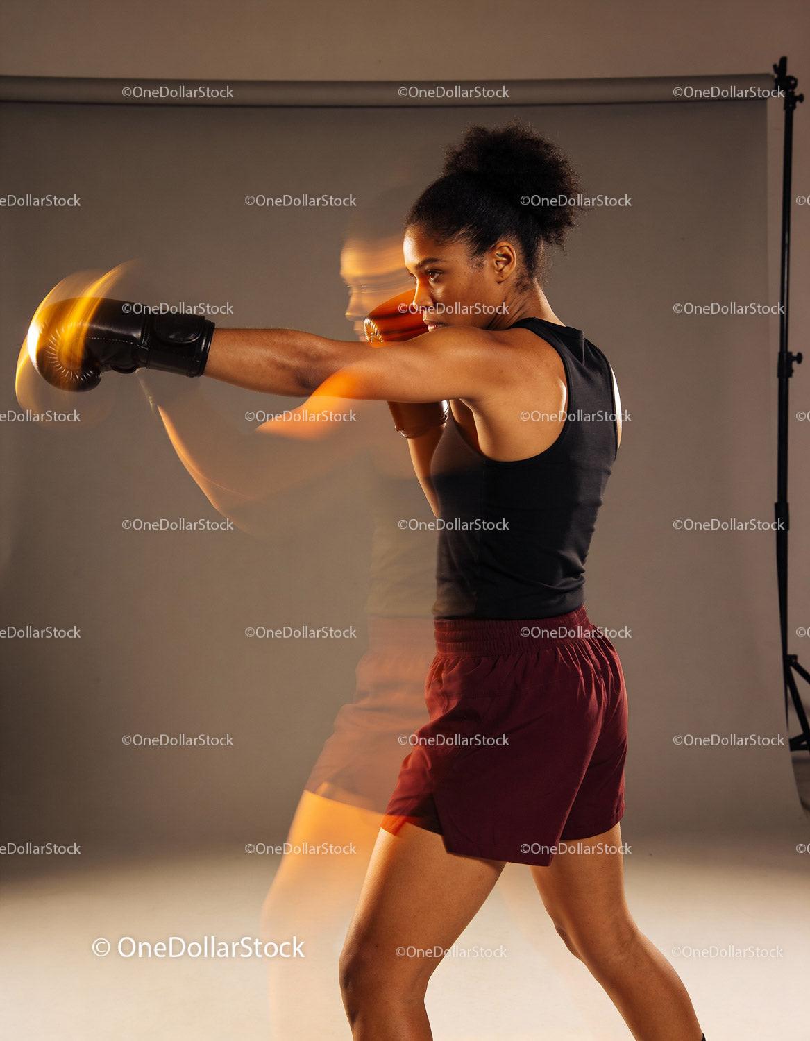 Focused female boxer delivering powerful punch with motion blur