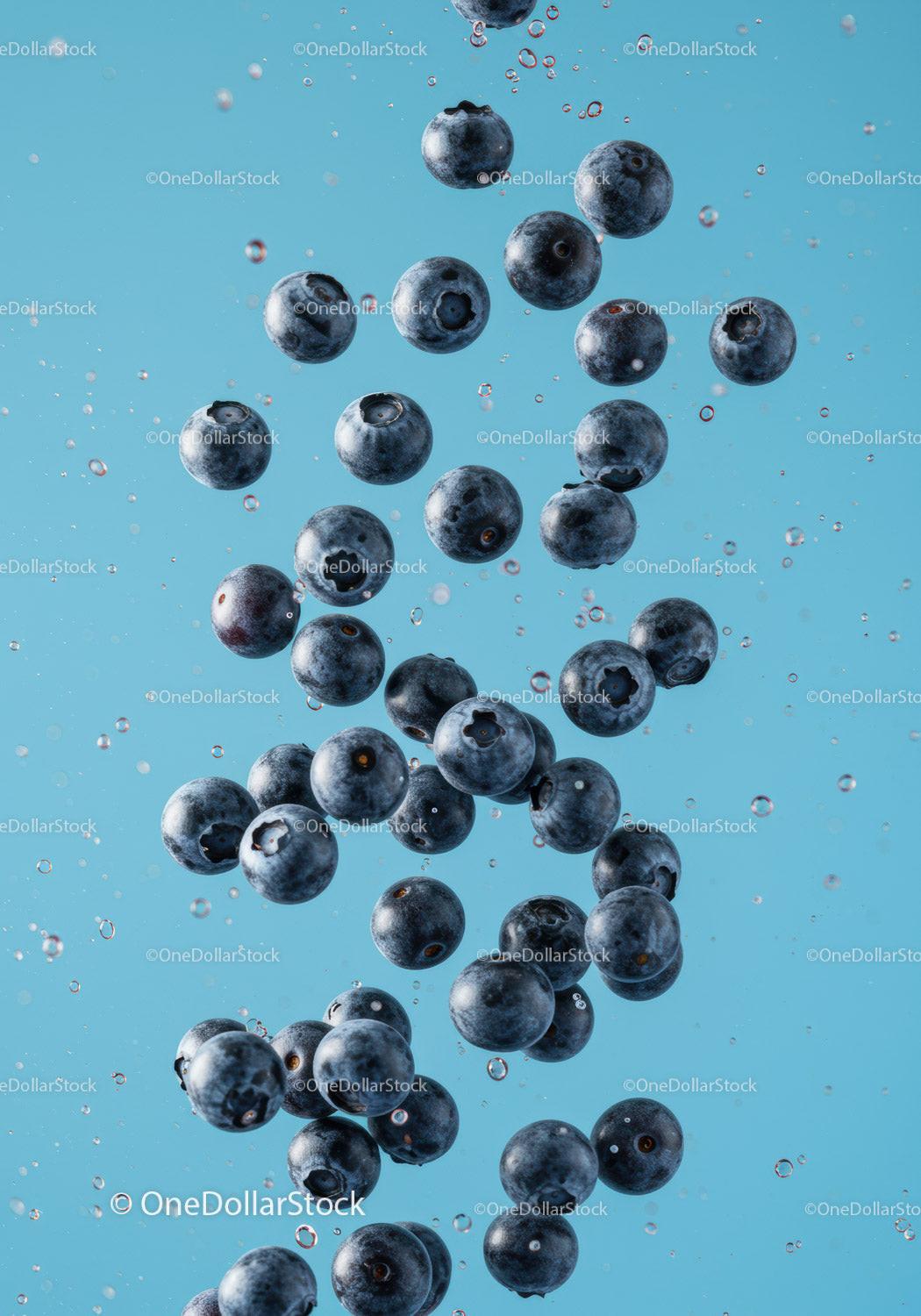 Fresh blueberries suspended in clear water droplets
