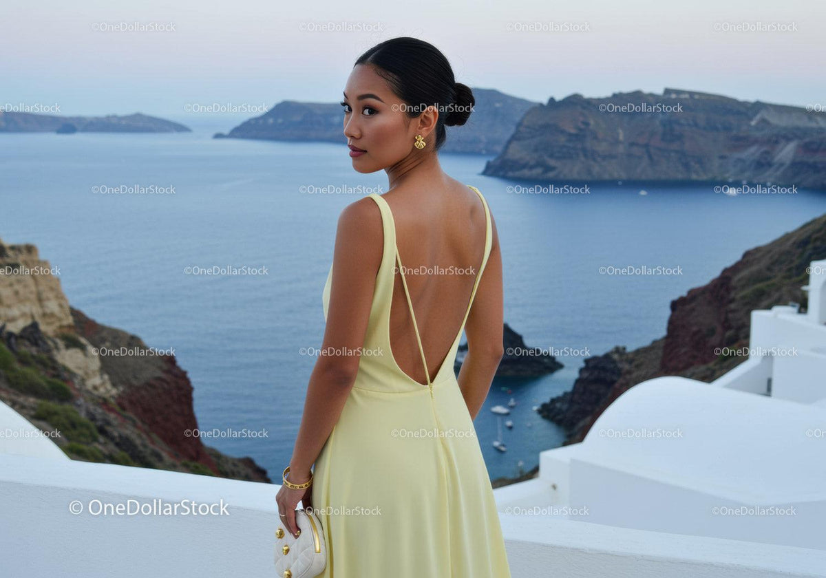Elegant woman in yellow dress overlooking sea cliffs