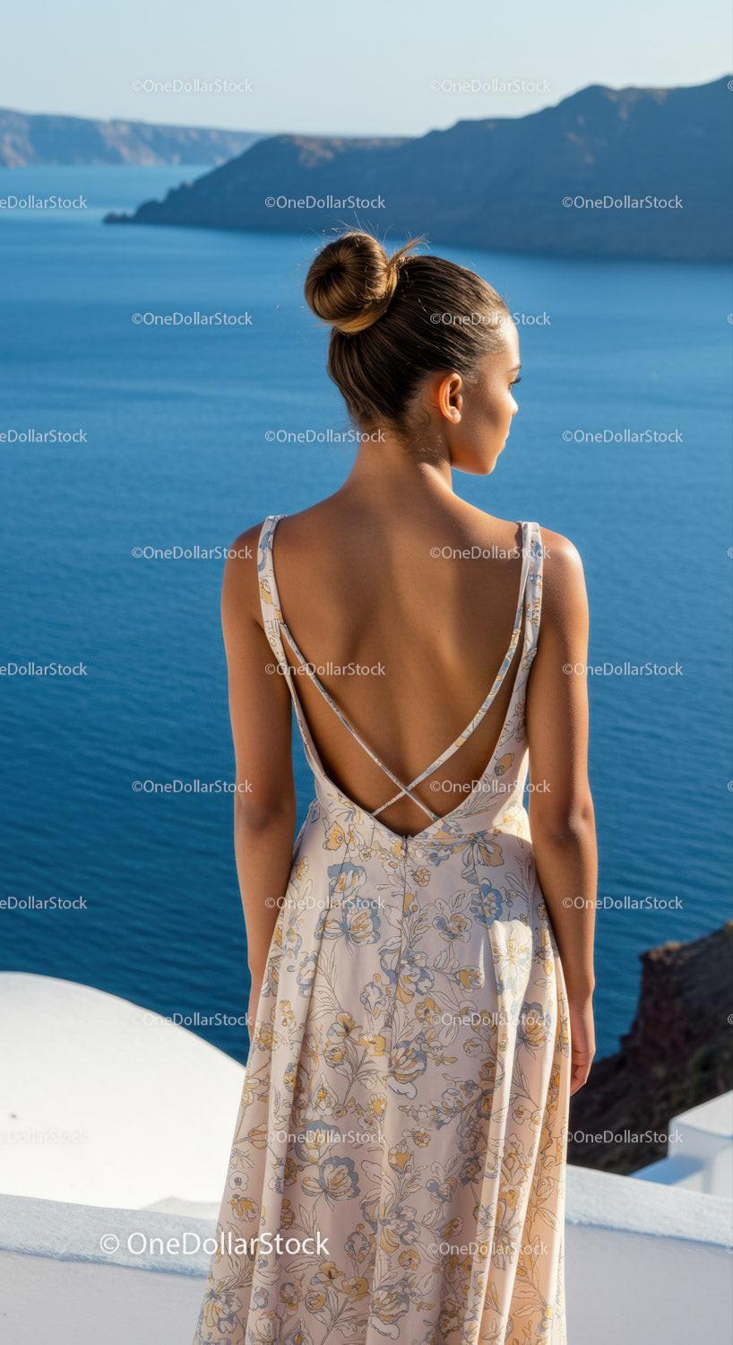 Woman in floral dress overlooking calm sea coast