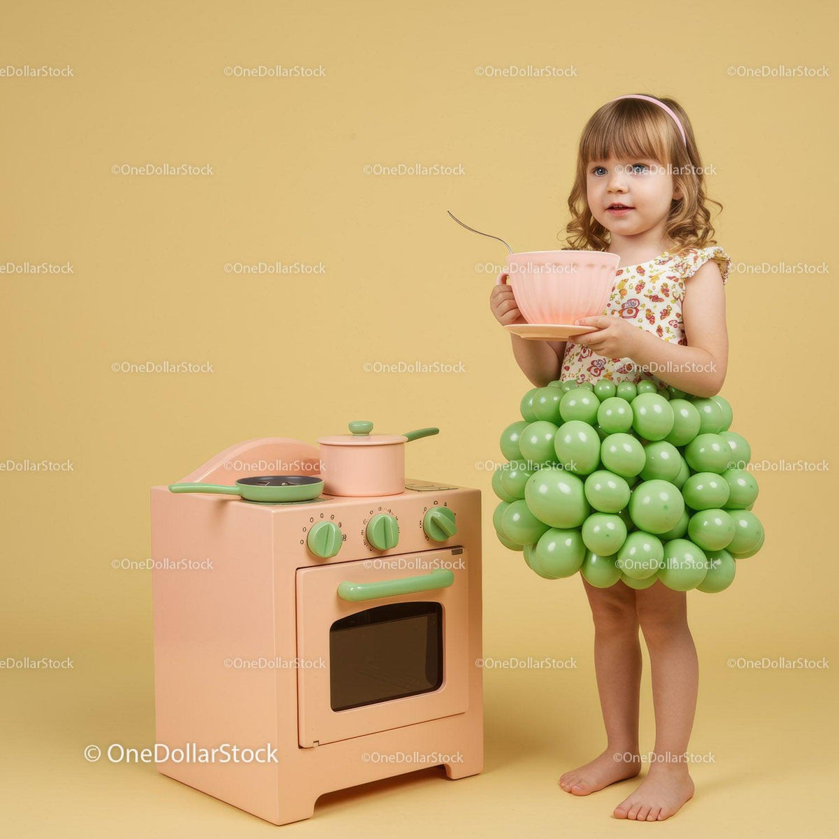 Little girl in playful balloon dress holding oversized cup