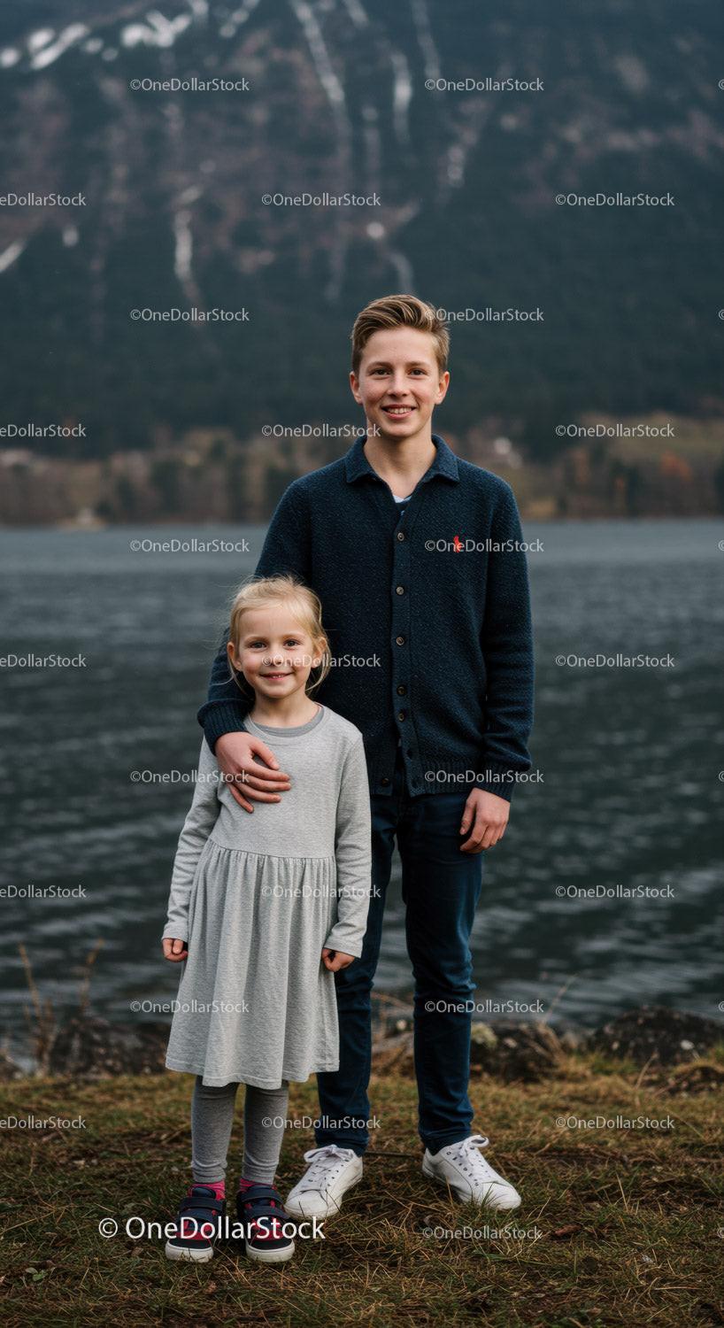 Young Siblings Enjoying Playful Moment by Lake with Mountain View