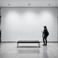Woman walking past empty bench in modern gallery space