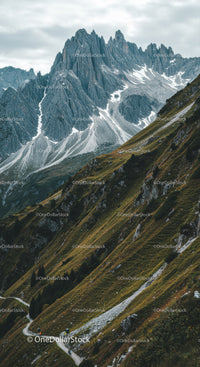 Majestic Rocky Mountain Peaks with Green Slopes and Snow Patches