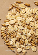 Close up of oat grains and flakes on brown background