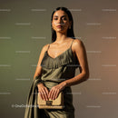 Elegant Woman in Satin Dress with Gold Accessories and Handbag