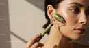 Close-up of a woman using a jade roller for facial massage and skincare