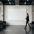 Businesswoman walking past blank canvas in modern office