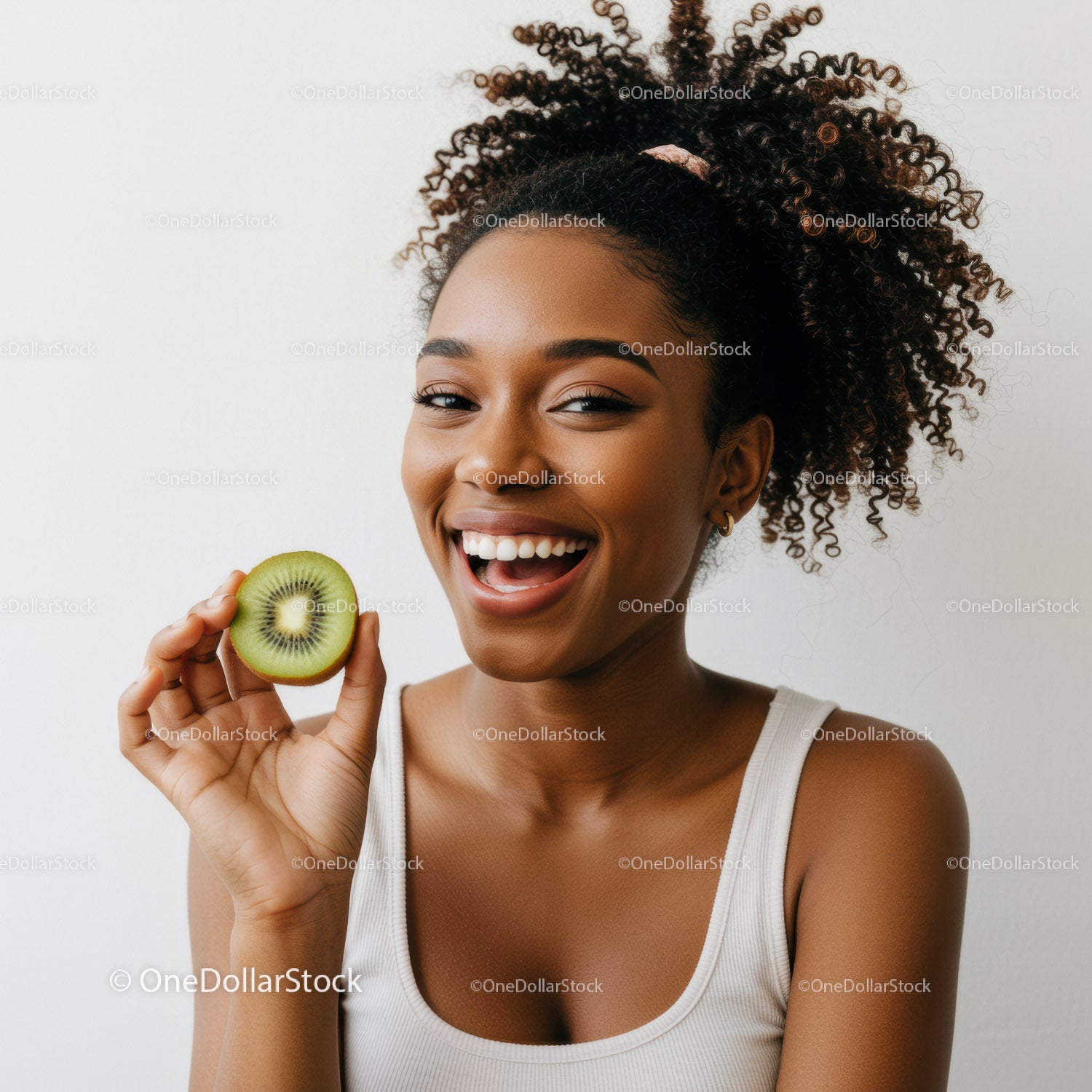 Vibrant Young Woman with Curly Hair Enjoying Fresh Kiwi Fruit