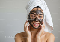 Young Woman with Facial Mask and Towel Wrap Preparing for Relaxation