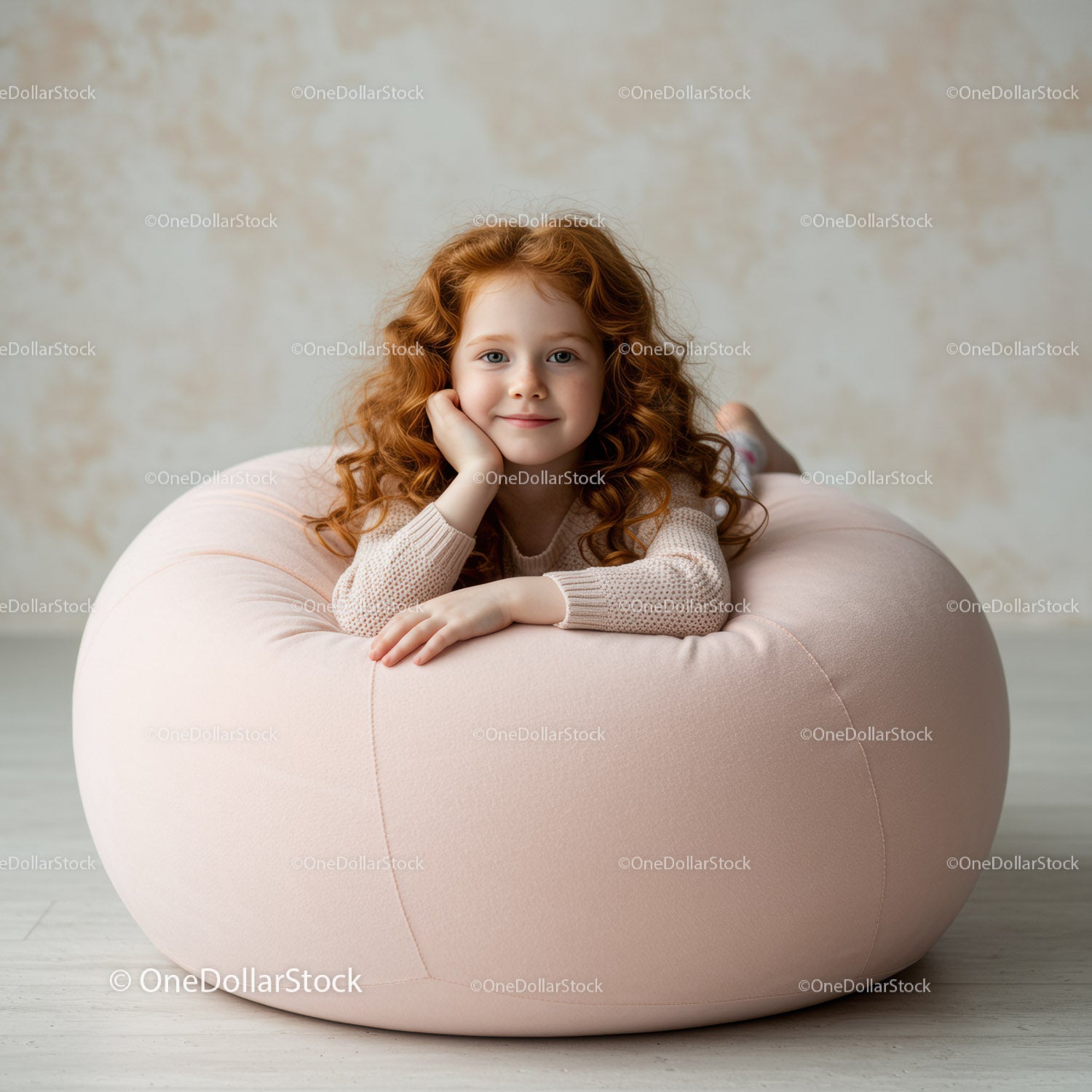 Redheaded girl relaxing on soft pink beanbag chair